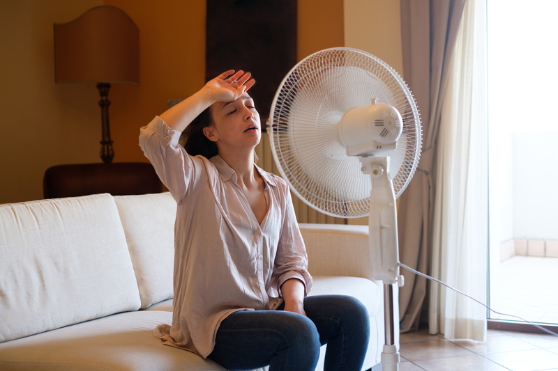 woman-trying-to-cool-down-with-fan