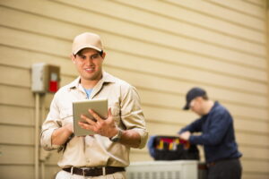 two-men-working-on-heat-pump-outside