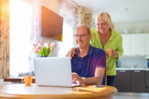 senior-couple-looking-at-laptop-computer-smiling