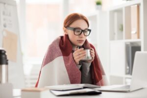 office-worker-wears-blanket-to-keep-warm-at-desk